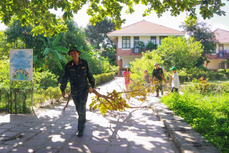 Cán bộ, đoàn viên, thanh niên Trường Sĩ quan Thông tin cùng các em Làng trẻ em SOS Nha Trang tham gia vệ sinh khuôn viên làng.