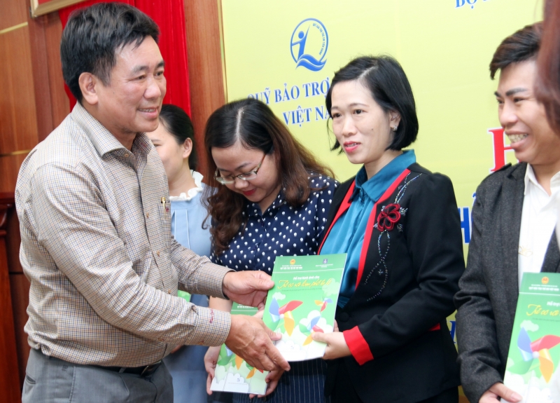 TS. BS Hoàng Văn Tiến, Giám đốc Quỹ Bảo trợ trẻ em Việt Nam tặng tài liệu cho các Trung tâm chăm sóc và dạy trẻ tự kỷ.