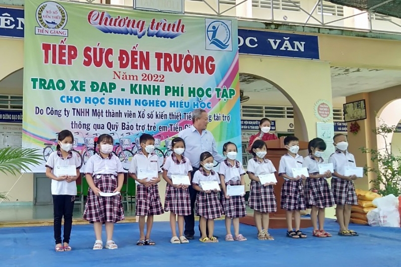 Ông Lê Văn Bé Chín - Giám đốc Quỹ Bảo trợ trẻ em tỉnh tặng quà cho các em học sinh.