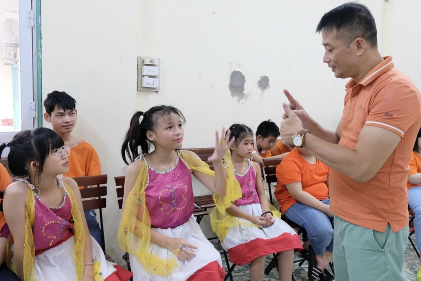 Thầy Sơn (ngoài cùng bên phải) trò chuyện với học trò bằng ngôn ngữ ký hiệu. Ảnh: TG